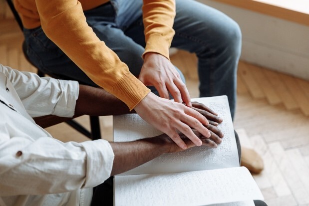 A woman touching an old book and helping a person